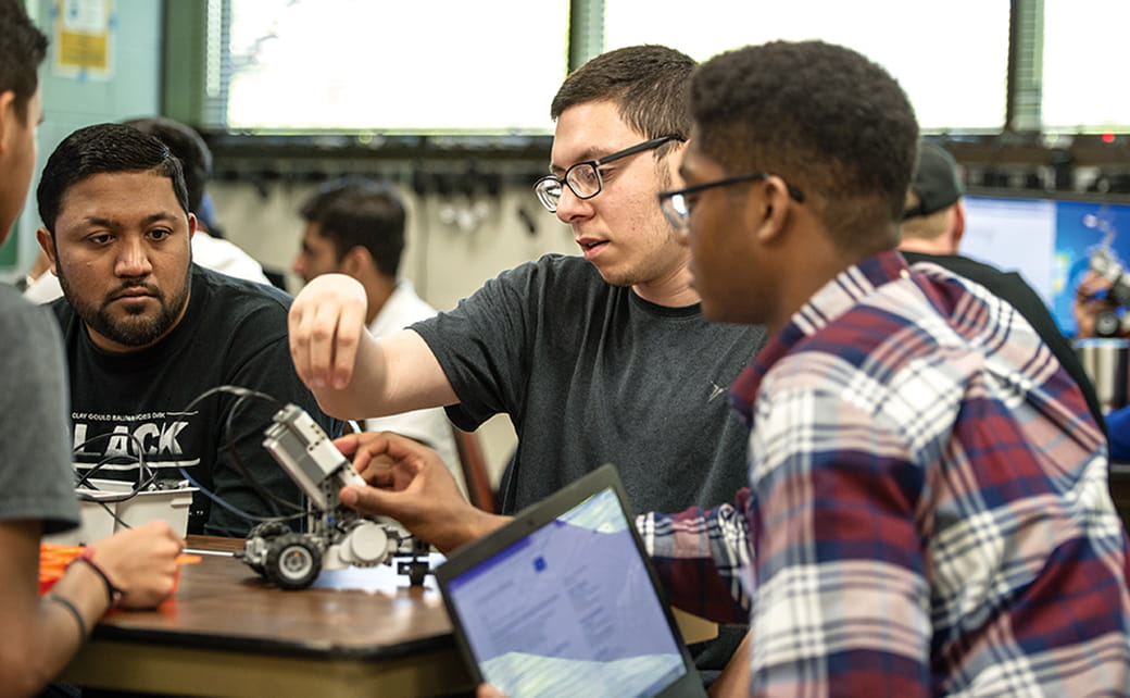A group of engineering students works together in an undergraduate lab class