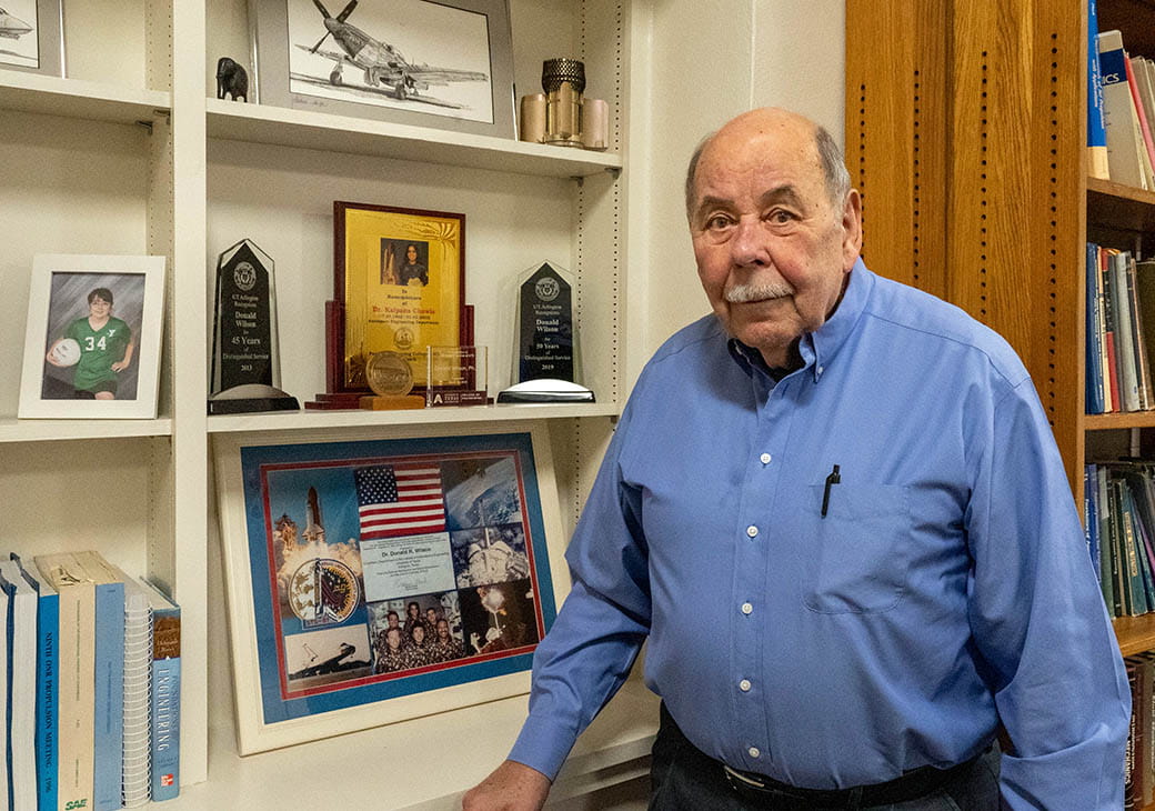 Mechanical and Aerospace Engineering Department Professor and Associate Chair Don Wilson standing in front of shelves of plaques and books in his office