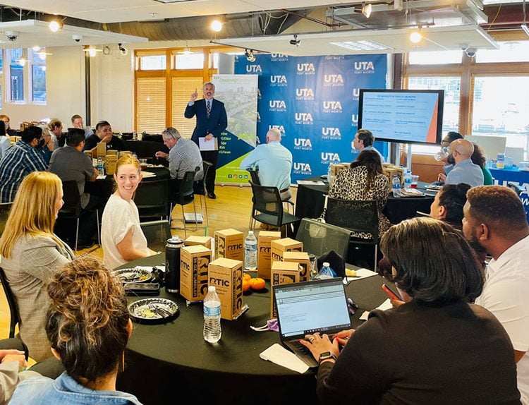 indoor event with people sitting at round tables during a presentation