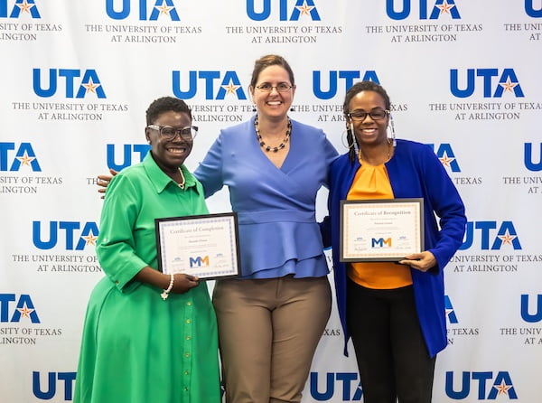 group photo of two women holding certificates with the u t a president inbetween