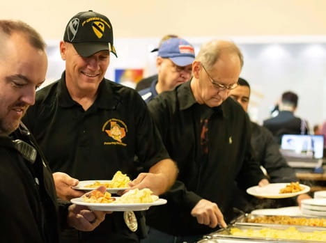 photograph of veterans lining up for breakfast at an event for military veterans