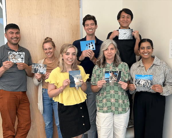 group of men and women holding up various postcards