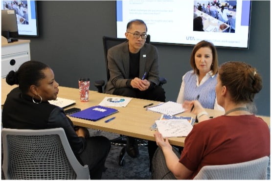 group of four people sitting at a conference table