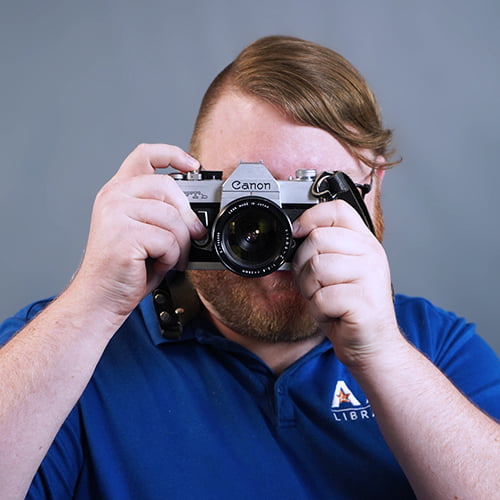U T A Employee holding up a camera