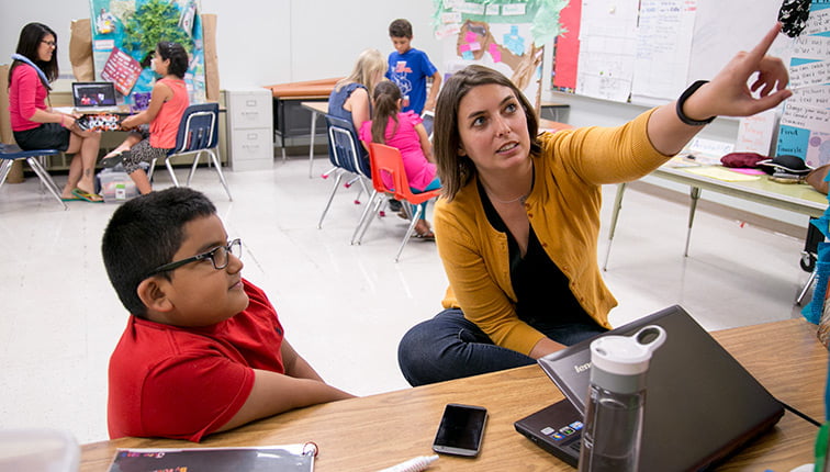 Teacher with student in classroom