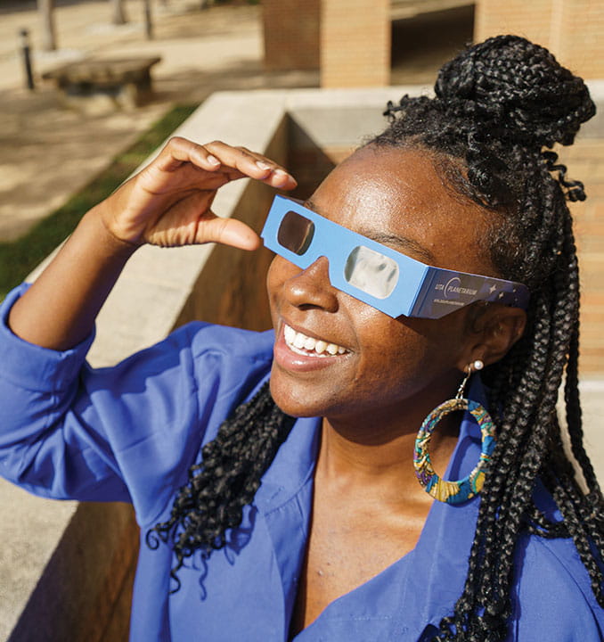 student wearing solar eclipse glasses
