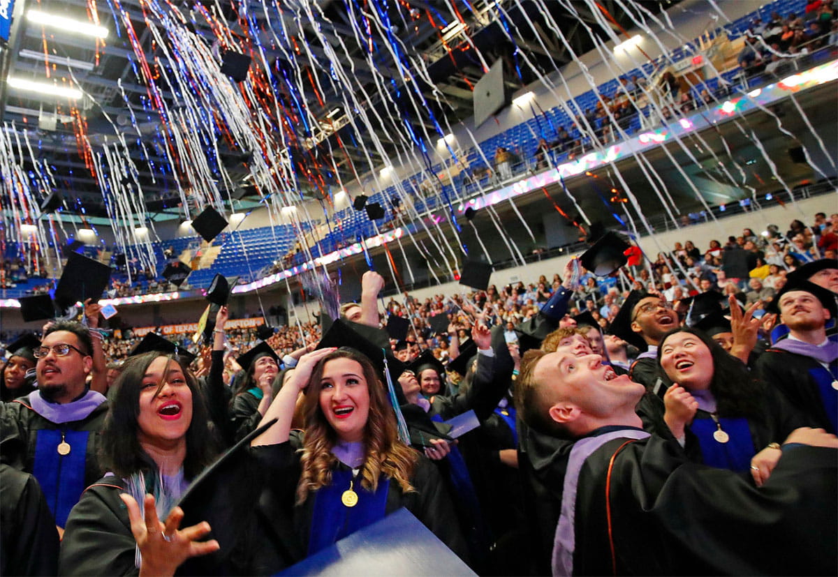 Graduating students tossing their caps at UTA Commencement Ceremony