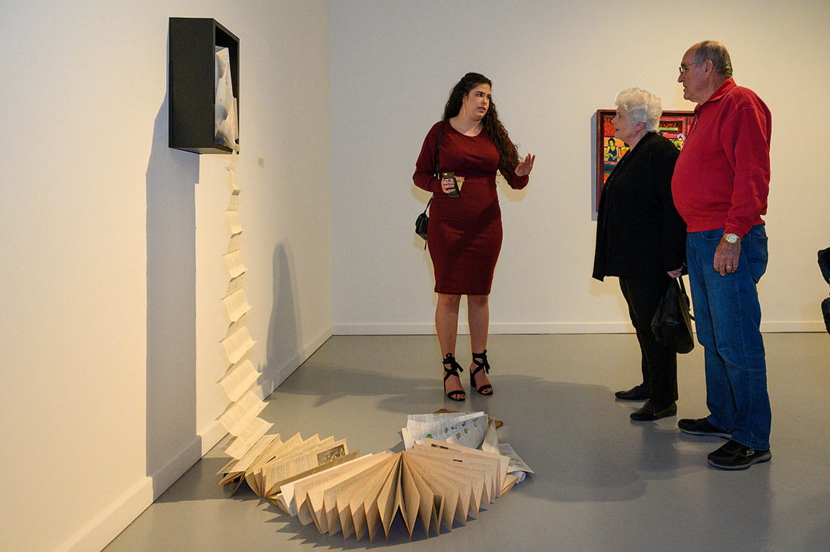 Madeline Ortega explains her piece Uncovered Context, featuring wood, an accordion book and bronze