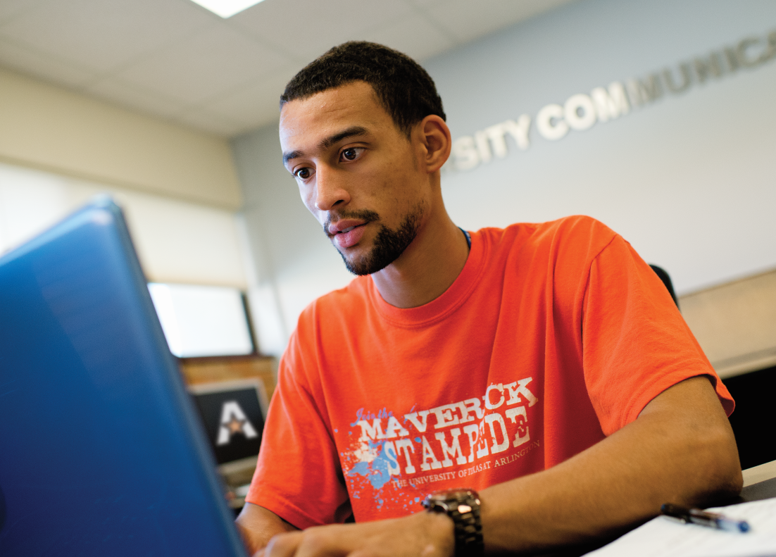 UTA student sitting at a laptop computer" _languageinserted="true