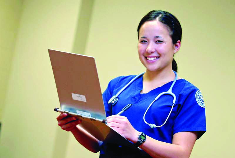 A nurse smiling holding a chart
