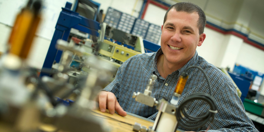 David Wetz smiles for a portrait in his laboratory.