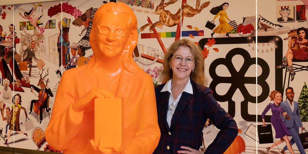 Minerva Cordero, professor of mathematics, stands next to a 3D-printed statue