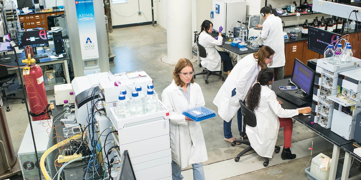 A group of researchers are busy at work in a crowded lab.