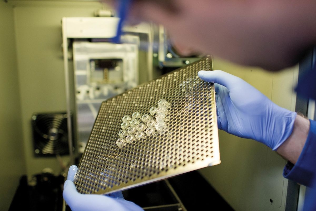 A researcher holds a computer board in a lab." _languageinserted="true