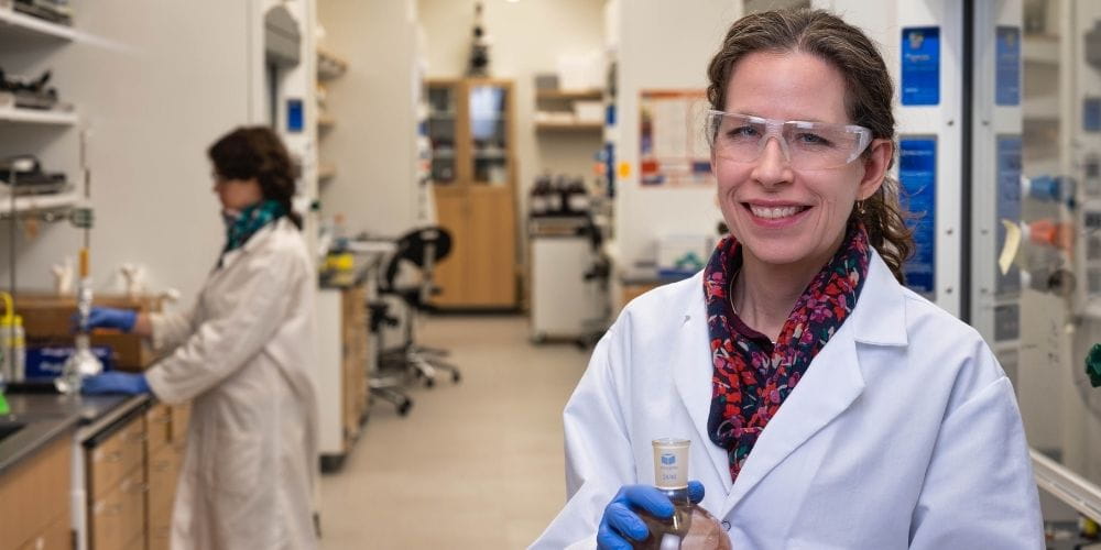 Sherri McFarland, chemistry professor, wears a lab coat in her laboratory." _languageinserted="true