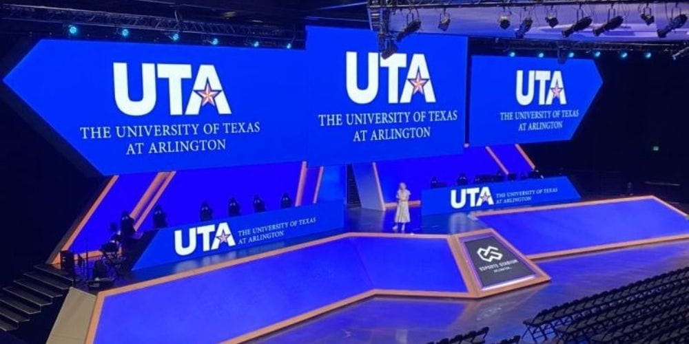 Image of stage at Arlington's esports stadium with UTA logos displayed on digital screens.