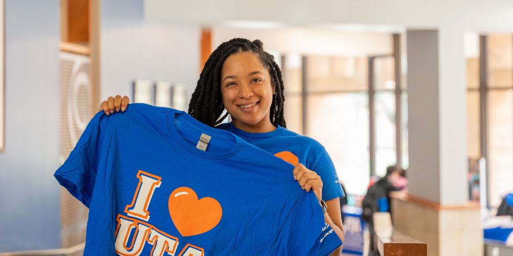 UTA student holds up t-shirt that says 