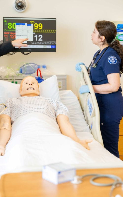 Nursing student interacts with mannequin
