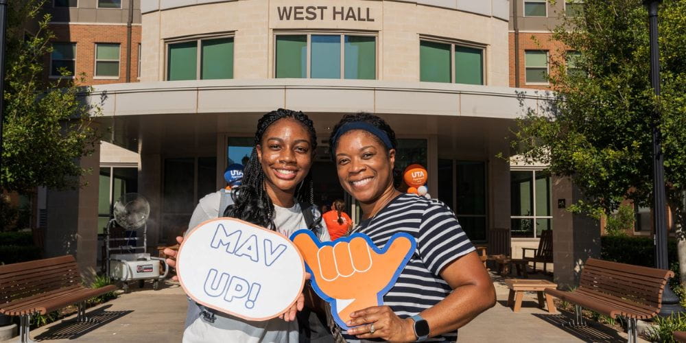 Incoming freshman and her mom pose in front of West Hall