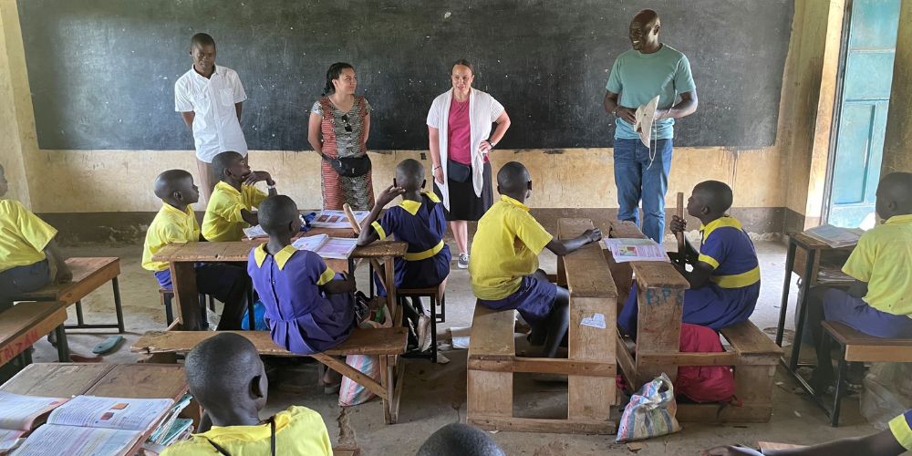 Photo of UTA faculty members speaking to classroom of Kenyan school students" _languageinserted="true