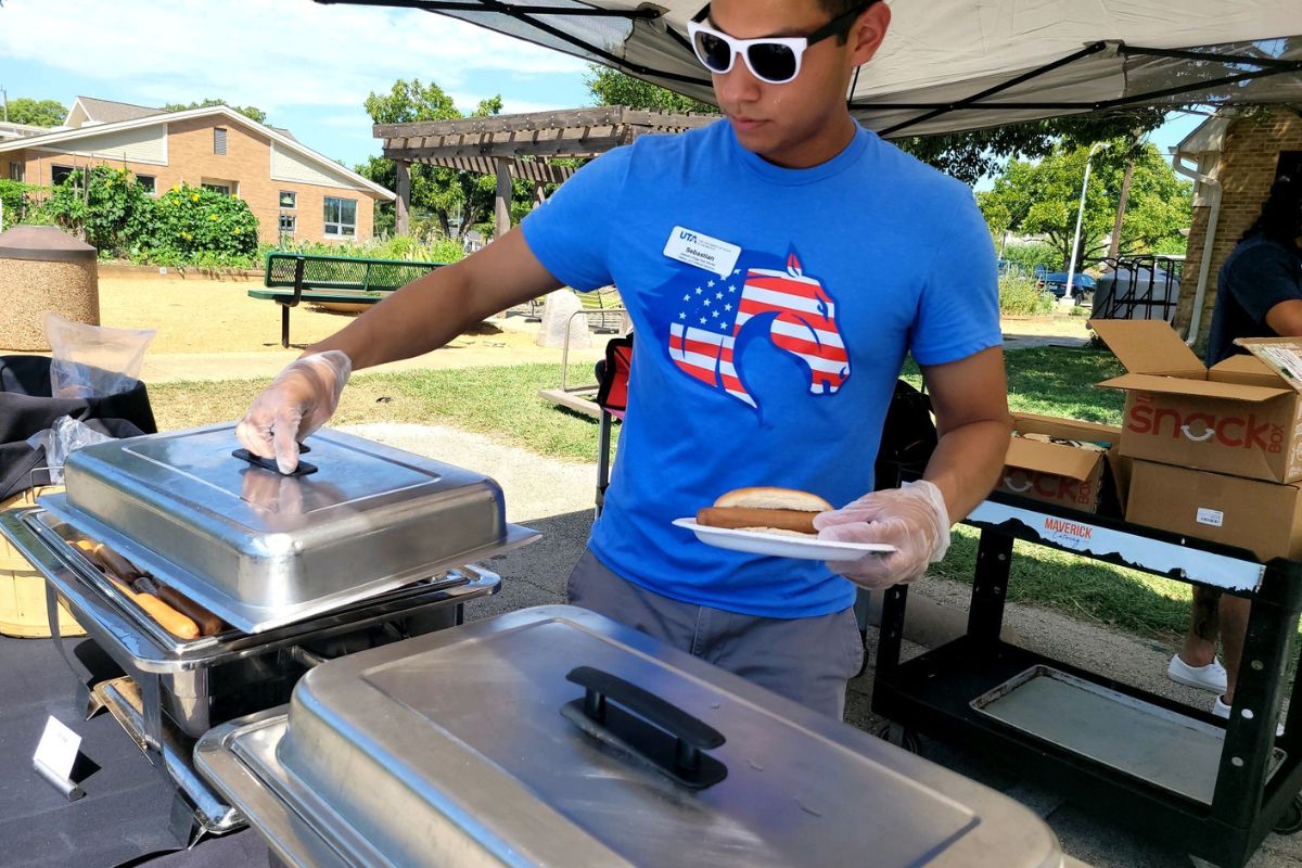 Photo of UTA student veteran Sebastian Molina serving food during an event