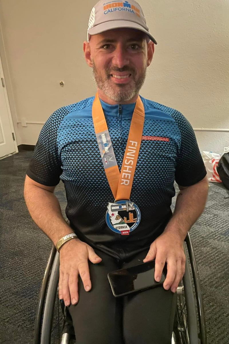 UTA sports nutrition expert Tyler Garner poses with his Ironman triathlon medal" _languageinserted="true