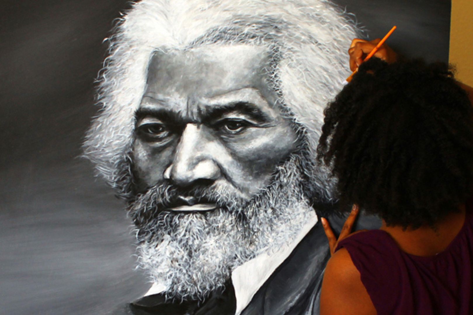 Image shows Letora Anderson working on her Frederick Douglass painting