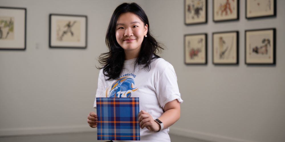 A portrait of Rachel Chen holding her tartan design 