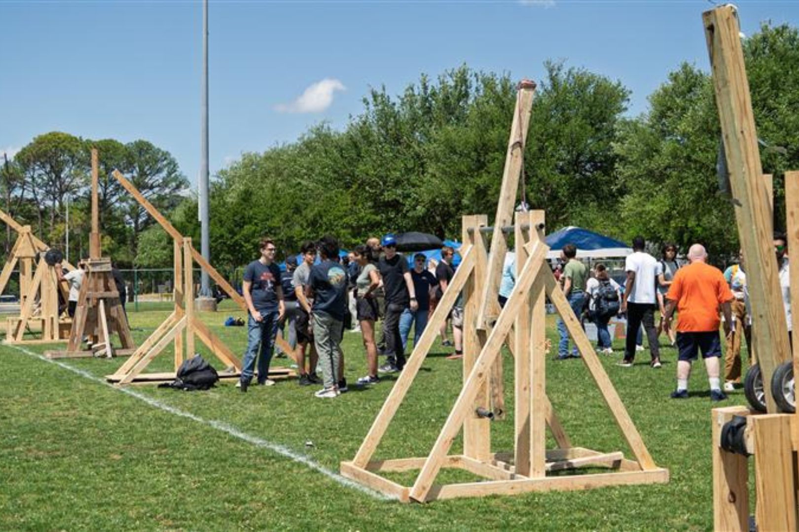 Image shows students testing their hand-built trebuchet