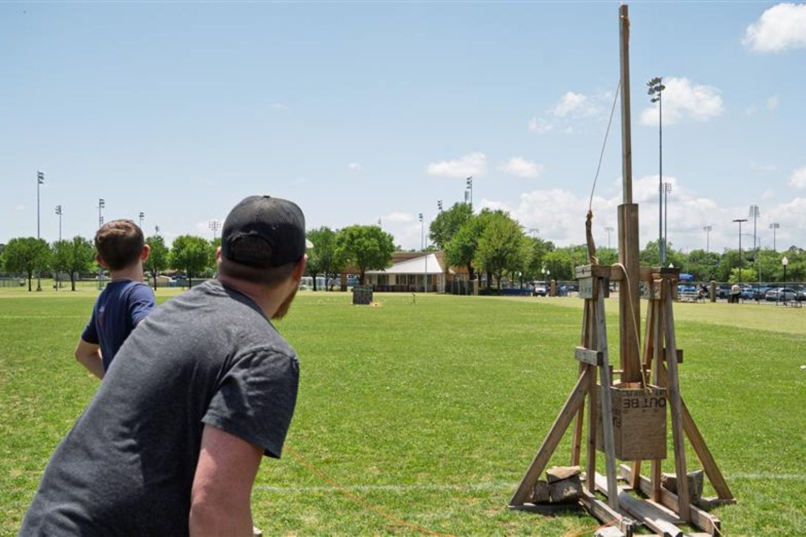 Image shows students testing their hand-built trebuchet