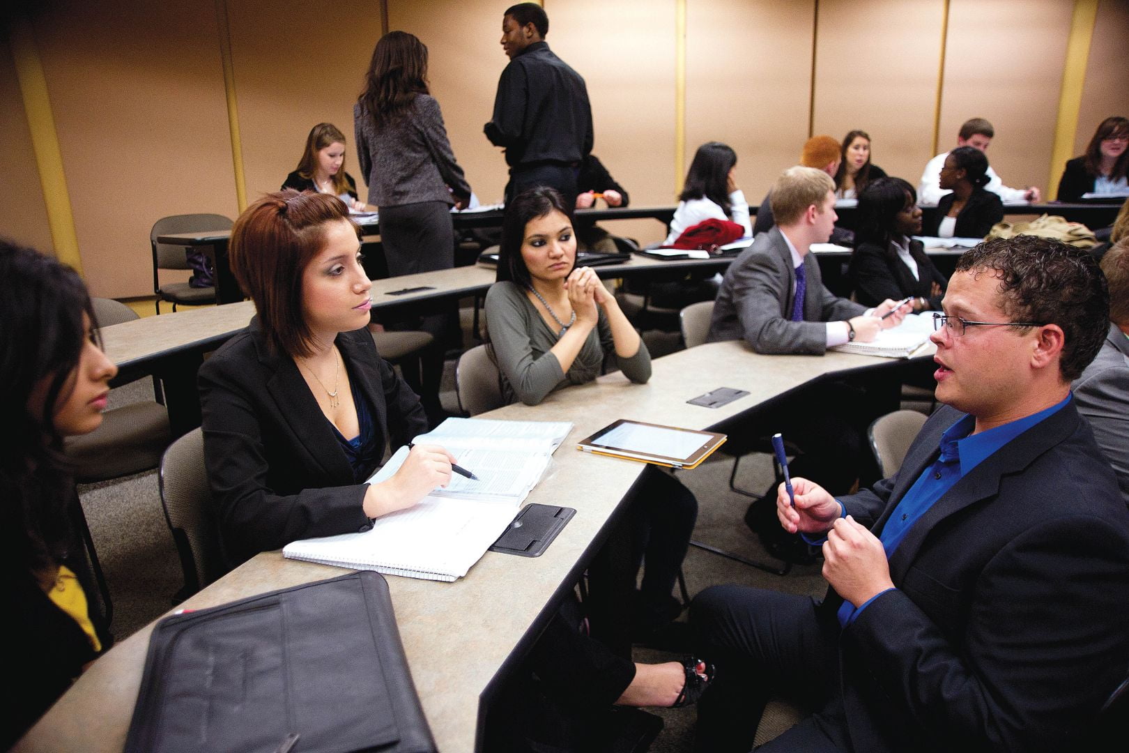 Image shows a UTA professor having a discussion with students in a classroom