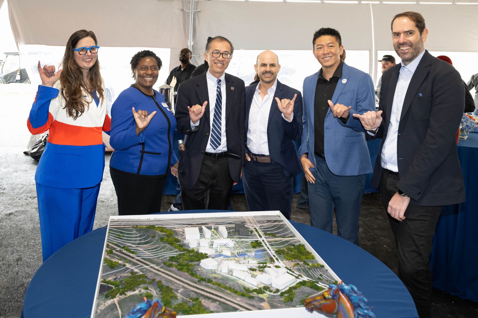 Image shows UTA officials Mavup in front of a model of the UTA West campus