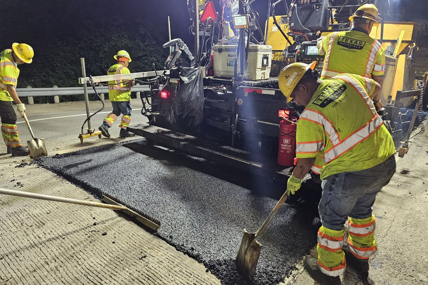 Image shows UTA students and faculty laying down the plastic-infused asphalt 