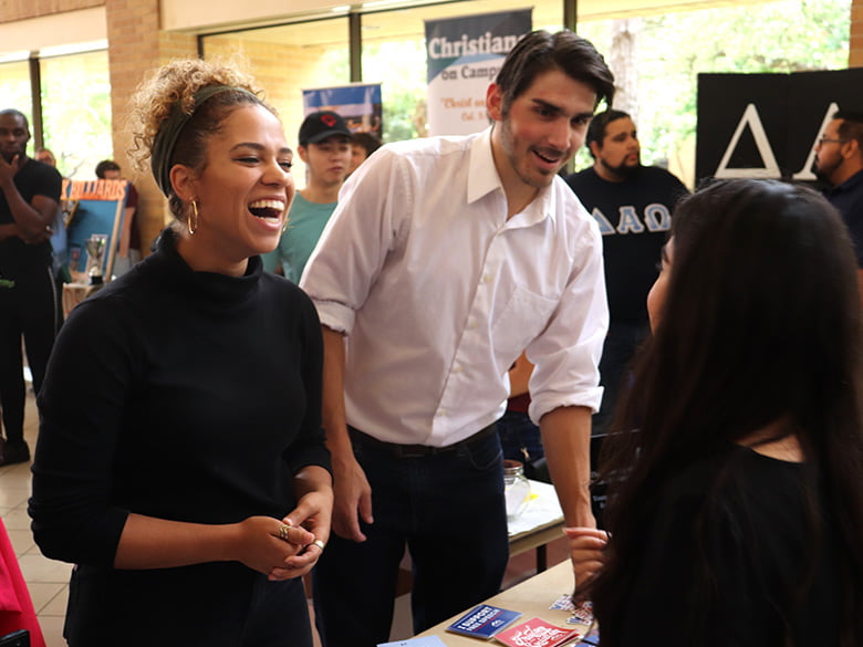 Sponsors talking with student at activity fair