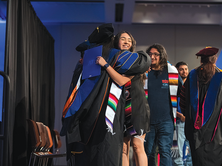 A graduate hugs an administrator
