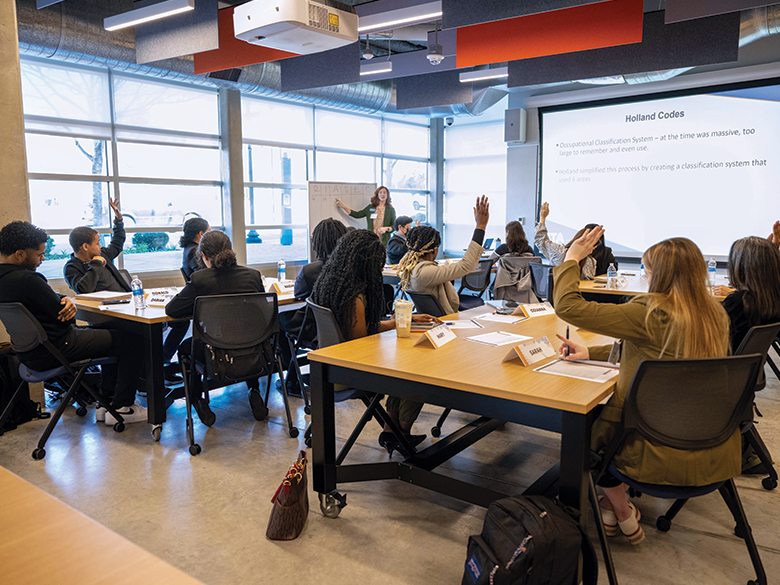 Students raise their hand in a lecture