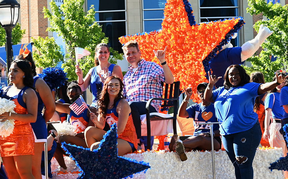 president cowley on the float in the uta 4th of july parade on campus