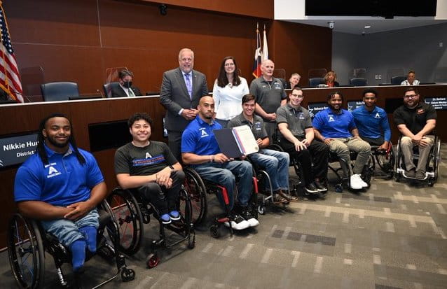 men's movin' mavs wheelchair basketball team with an award at arlington city council meeting