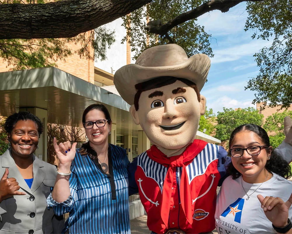 President Cowley does Mav-Up pose for a photo with Texas State Fair mascot Little Big Tex and student