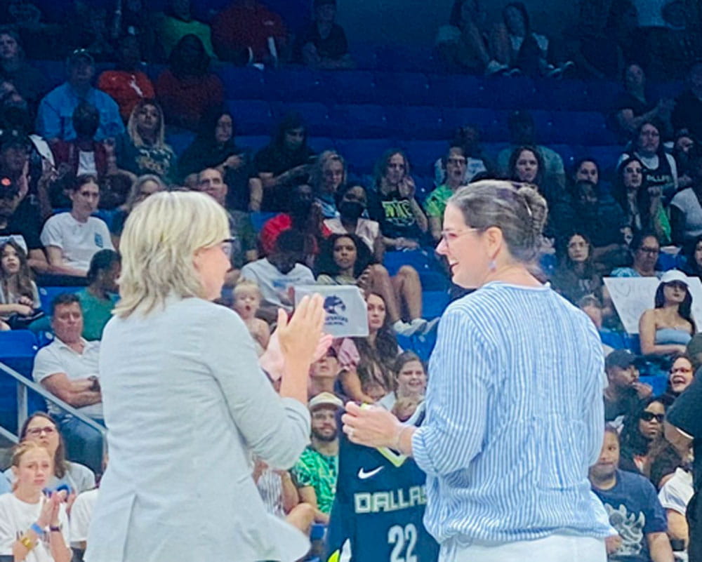 president cowley on the basketball court at the dallas wings game