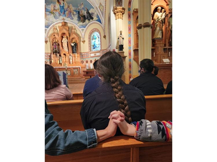 Image of family holding hands at the St. Charles Church in South Dakota on the Rosebud Indian Reservation.