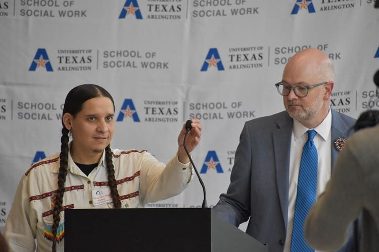 MSW student, Stephen Silva-Brave, left and Dr. Kirk Foster, dean of the UTA School of Social Work standing at the podium during the Dean's Alumni Breakfast March 21 in the SWSH building. 