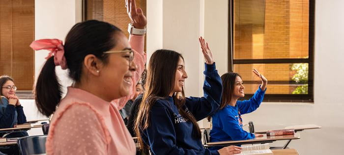 Student raising their hand up in classroom