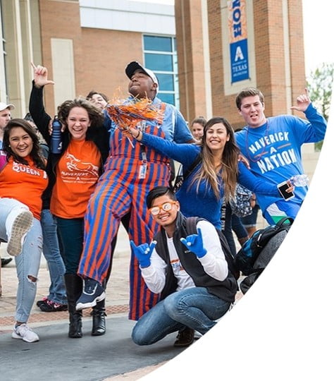 UTA student smiling and holding up the Mav sign