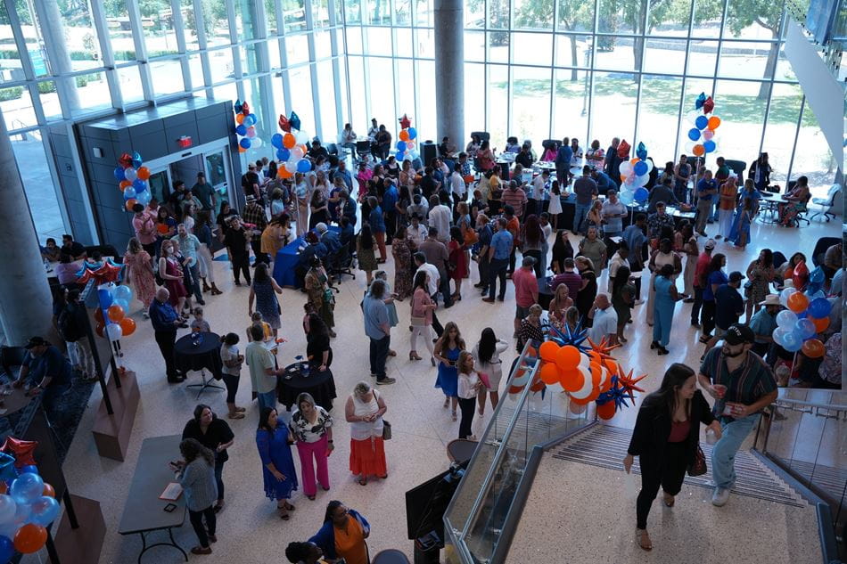 Students, faculty and staff in the lobby area of the School of Social Work and Smart Hospital building