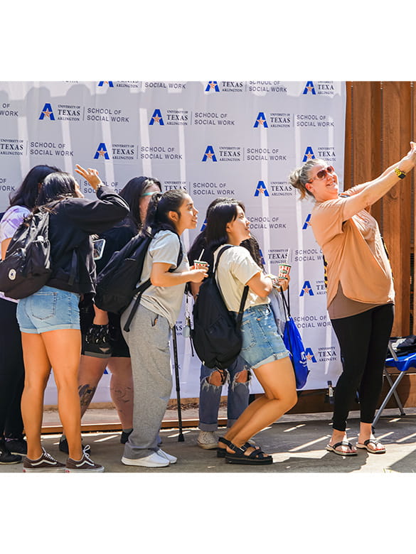 Student taking a picture during UTA Stampede event  in SSW courtyard