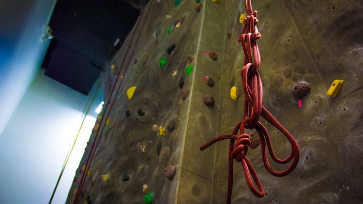 Climbing wall with a belay rope hanging from the ceiling