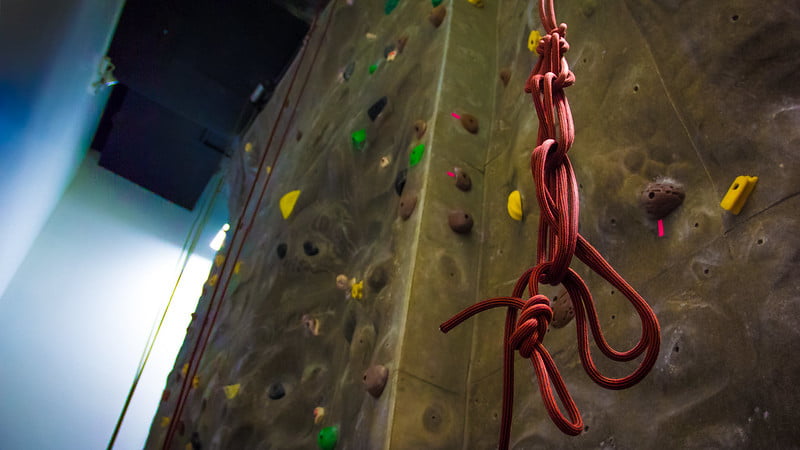 Climbing wall with a belay rope hanging from the ceiling