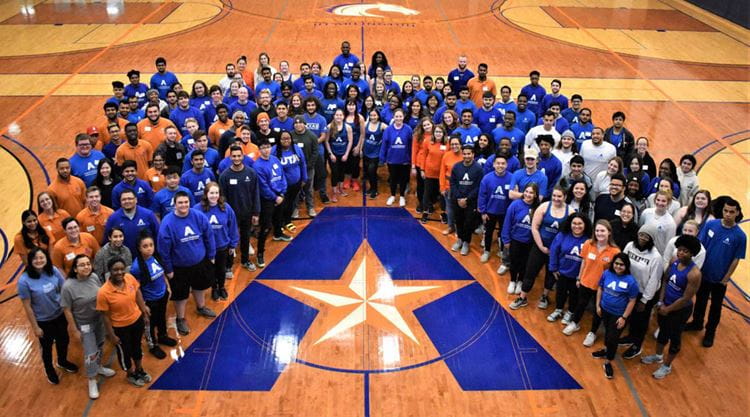 Faculty and staff of Campus Rec circled around the UTA logo for a group picture