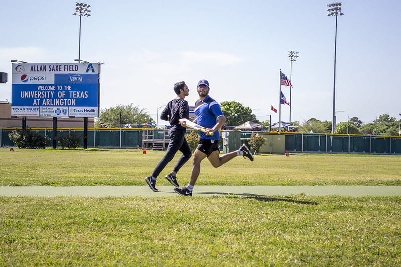 Two men passing each other during a game of intramural cricket